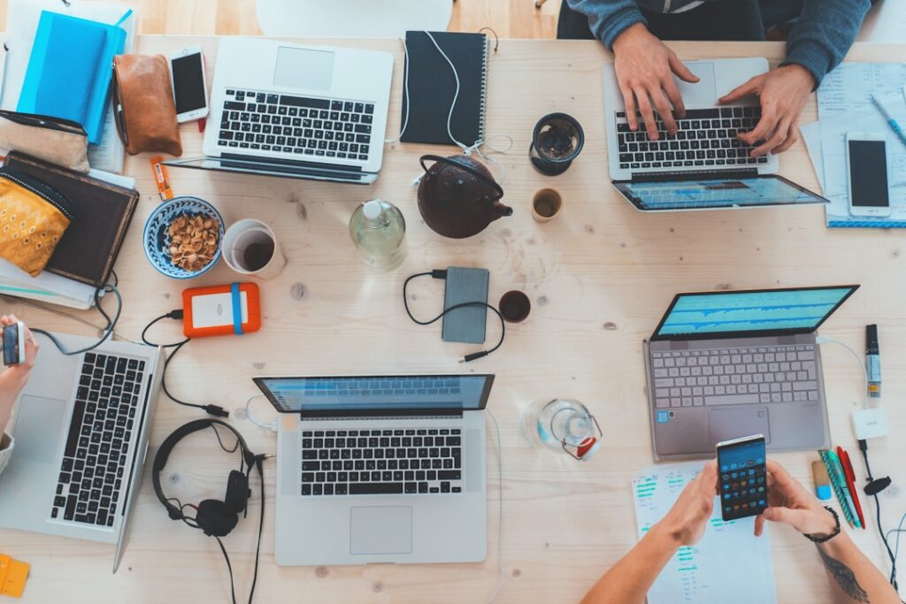 A group of individuals collaborating on laptops at a table, focused on digital marketing and newsletter tools.